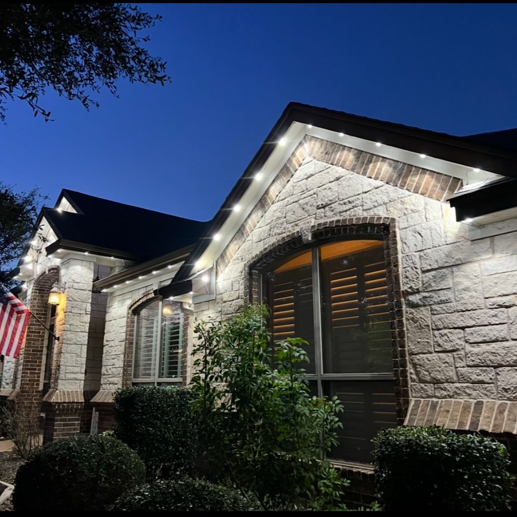 Warm white and purple permanent LED roofline lights on a home at dusk