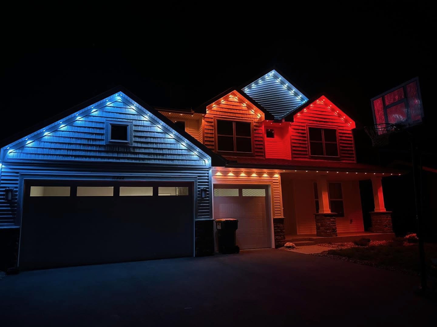 Blue and red permanent LED gable lighting on a craftsman home